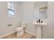 Modern powder room with pedestal sink and wood-look flooring at 11076 Star Fall St, Littleton, CO 80125
