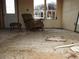 Empty living room with damaged floor and single chair at 67500 E County Road 38 E Rd, Byers, CO 80103