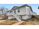 Gray ranch home with a two-car garage and stairs leading to the entrance at 9132 Fayette St, Denver, CO 80260