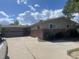 Brick ranch home with attached garage and a large driveway at 1515 S Monaco Pkwy, Denver, CO 80224
