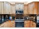 Modern kitchen with wood cabinets, granite countertops, and stainless steel appliances at 6763 Deer Path, Evergreen, CO 80439