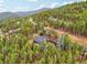 Aerial view of house nestled in wooded area at 6763 Deer Path, Evergreen, CO 80439