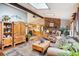Open living room with a stone fireplace and views into the kitchen area at 6763 Deer Path, Evergreen, CO 80439