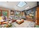 Living room with vaulted ceiling, skylights, and wood floors at 6763 Deer Path, Evergreen, CO 80439