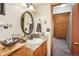 Simple bathroom with vanity, toilet, and access to stairs at 6763 Deer Path, Evergreen, CO 80439