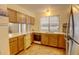 Galley style kitchen with wood cabinets, built in microwave and dishwasher at 1050 S Monaco Pkwy # 88, Denver, CO 80224