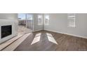 Bright living room featuring hardwood floors, a fireplace, and sliding glass doors at 1815 Chaffee Crest Dr, Berthoud, CO 80513
