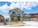 Two-story house with light beige siding, stone accents, and a two-car garage at 1815 Chaffee Crest Dr, Berthoud, CO 80513
