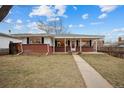 Brick ranch home with covered porch and landscaped yard at 4109 S Acoma St, Englewood, CO 80110