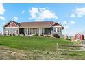 House exterior showcasing a spacious lawn and a country setting at 54333 E County Road 26, Strasburg, CO 80136
