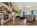 Spacious living room with a stone fireplace, hardwood floors, and ample natural light at 54333 E County Road 26, Strasburg, CO 80136