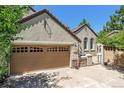 Tan two-story home with a three-car garage and arched entryway at 5021 Ballarat Ln, Castle Rock, CO 80108