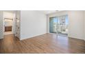 Bright bedroom with wood-look flooring and access to a private balcony at 6153 N Ceylon St # 303, Denver, CO 80249