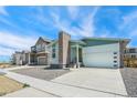 Modern two-story house with light green siding and brick chimney at 9360 Bahama Ct, Commerce City, CO 80022