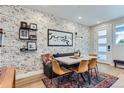 Charming dining area with a rustic brick accent wall and modern table at 2571 W 69Th Pl, Denver, CO 80221