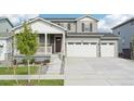 Two-story home with gray siding, white trim, and a three-car garage at 3322 N Highlands Creek Pkwy, Aurora, CO 80019