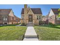 Front view of a brick house with a gabled roof, front steps and a well-maintained lawn at 3734 W 26Th Ave, Denver, CO 80211