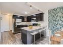 Modern kitchen with dark cabinetry, granite countertops, and stainless steel appliances at 909 N Logan St # 4A, Denver, CO 80203