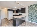 Updated kitchen, featuring dark cabinetry and granite countertops at 909 N Logan St # 4A, Denver, CO 80203