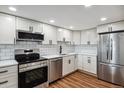 Modern kitchen with white cabinets and stainless steel appliances at 14152 E Linvale Pl # 203, Aurora, CO 80014