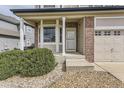 Brick and siding home exterior with a covered porch and well-manicured landscaping at 6172 S Yampa St, Aurora, CO 80016