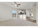 Open living room with neutral carpeting, vinyl flooring, and kitchen views at 2992 Oxley St, Strasburg, CO 80136
