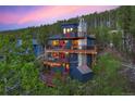 Aerial view of a modern mountain home with expansive decks and mountain backdrop at 141 Shekel Ln, Breckenridge, CO 80424