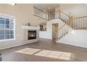 Bright living room with a fireplace, hardwood floors, and high ceilings at 7353 Norfolk Pl, Castle Pines, CO 80108
