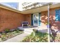 Brick front porch with teal door and small seating area at 6431 W Arbor Ave, Littleton, CO 80123