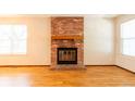 Brick fireplace in living room with wood mantel and hearth at 12133 Bannock Cir # D, Denver, CO 80234