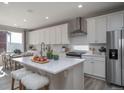 Bright, open kitchen with white cabinets, stainless steel appliances, and large island at 5176 N Quemoy Ct, Aurora, CO 80019