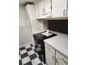 Kitchen with white cabinets, black appliances, and a checkerboard floor at 12172 Huron St # 207, Denver, CO 80234