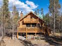 Rustic log cabin with deck and mountain backdrop at 878 American Way, Breckenridge, CO 80424