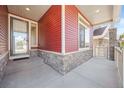 Covered porch with stonework and a gray door at 1178 Freedom Way, Castle Rock, CO 80109
