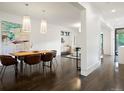 Open concept dining room with a wooden table, leather chairs, and dark hardwood floors at 1253 Elizabeth St, Denver, CO 80206