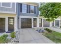 Gray townhome exterior with double-car garage and landscaping at 12008 E Tennessee Dr, Aurora, CO 80012