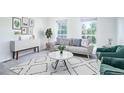 Living room with gray couch, green armchairs, and a coffee table at 12008 E Tennessee Dr, Aurora, CO 80012