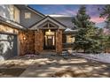 Inviting entryway with stone pillars and a wood door, leading into the home at 3244 Elk View Dr, Evergreen, CO 80439