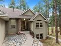Inviting ranch home with stone pathway, and mature trees at 4381 Cheyenne Dr, Larkspur, CO 80118