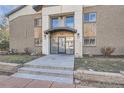 Modern building entrance with glass doors and stone steps at 2460 W Caithness Pl # 104, Denver, CO 80211