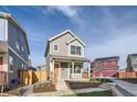 Two-story gray house with orange door, wooden fence, and small front yard at 10291 E 62Nd Pl, Denver, CO 80238