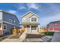 Two-story gray house with orange door, wooden fence, and small front yard at 10291 E 62Nd Pl, Denver, CO 80238