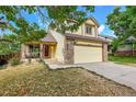 Two story house with a yellow exterior, two car garage, and landscaping at 19873 E Vassar Ave, Aurora, CO 80013
