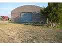 Large block barn with a roll-up door at 2024 Strasburg Rd, Strasburg, CO 80136