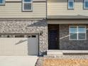 Two-story house with stone accents and a three-car garage at 6124 Hourglass Dr, Brighton, CO 80601