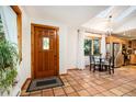 Bright entryway with terracotta tile floors and a wood door leading into the home at 28192 Shadow Mountain Dr, Conifer, CO 80433