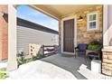 Covered front porch with stone facade, chairs and planters at 9785 Mount Kataka Pt, Littleton, CO 80125