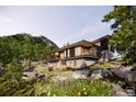 Modern home nestled in mountains with large windows and stone accents at 53 Canyon Pines Dr, Arvada, CO 80403