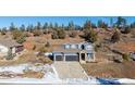 Two-story house with gray siding, two-car garage, and a landscaped yard at 4285 Mohawk Dr, Larkspur, CO 80118