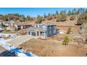 Two-story house with gray siding, two-car garage, and a landscaped yard at 4285 Mohawk Dr, Larkspur, CO 80118